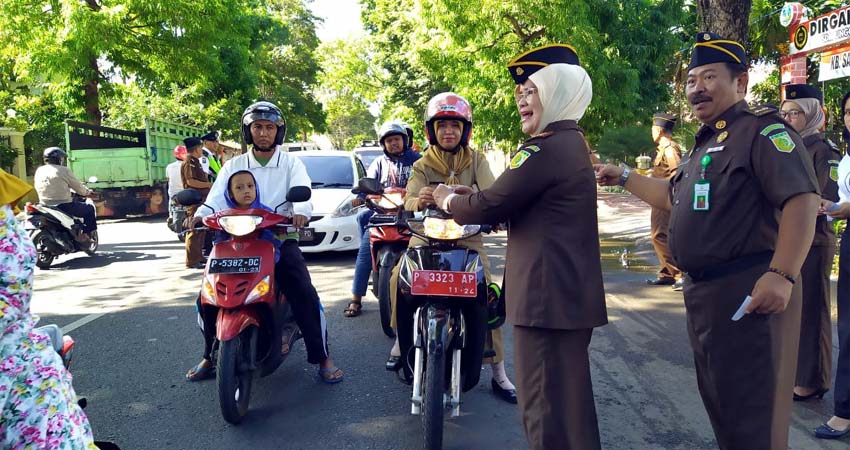 Ibu Unaisi Hetty Nining Kajari Bondowoso saat membagikan stiker kepada para pengendara.(foto dul.memontum.com)